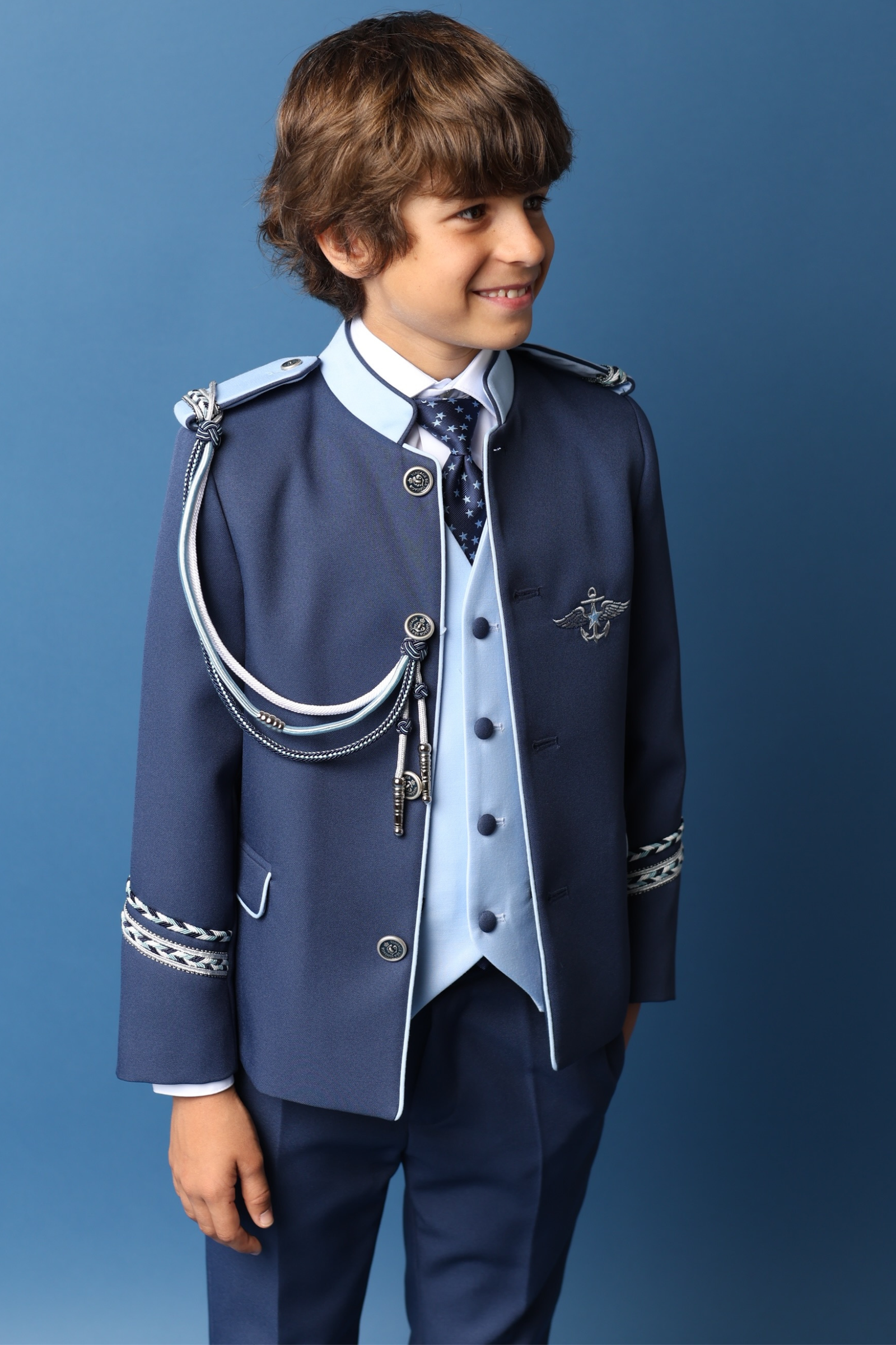 Niño con traje almirante en azul marino y detalles plateados, ideal para comuniones 2025.