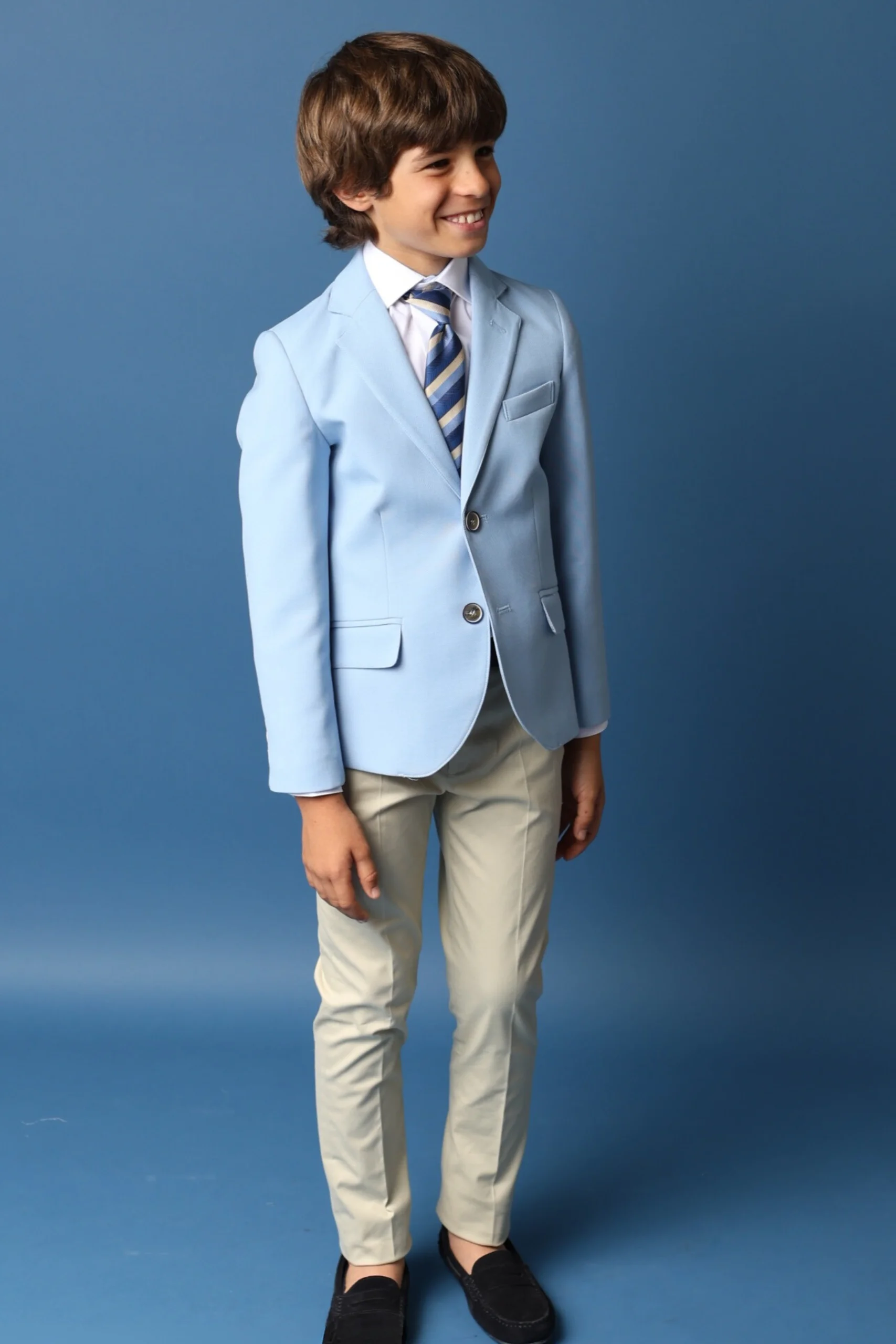 Traje de Comunión 2025 en Azul Claro y Beige Niño con traje de comunión en azul claro y pantalones beige, perfecto para comuniones 2025.