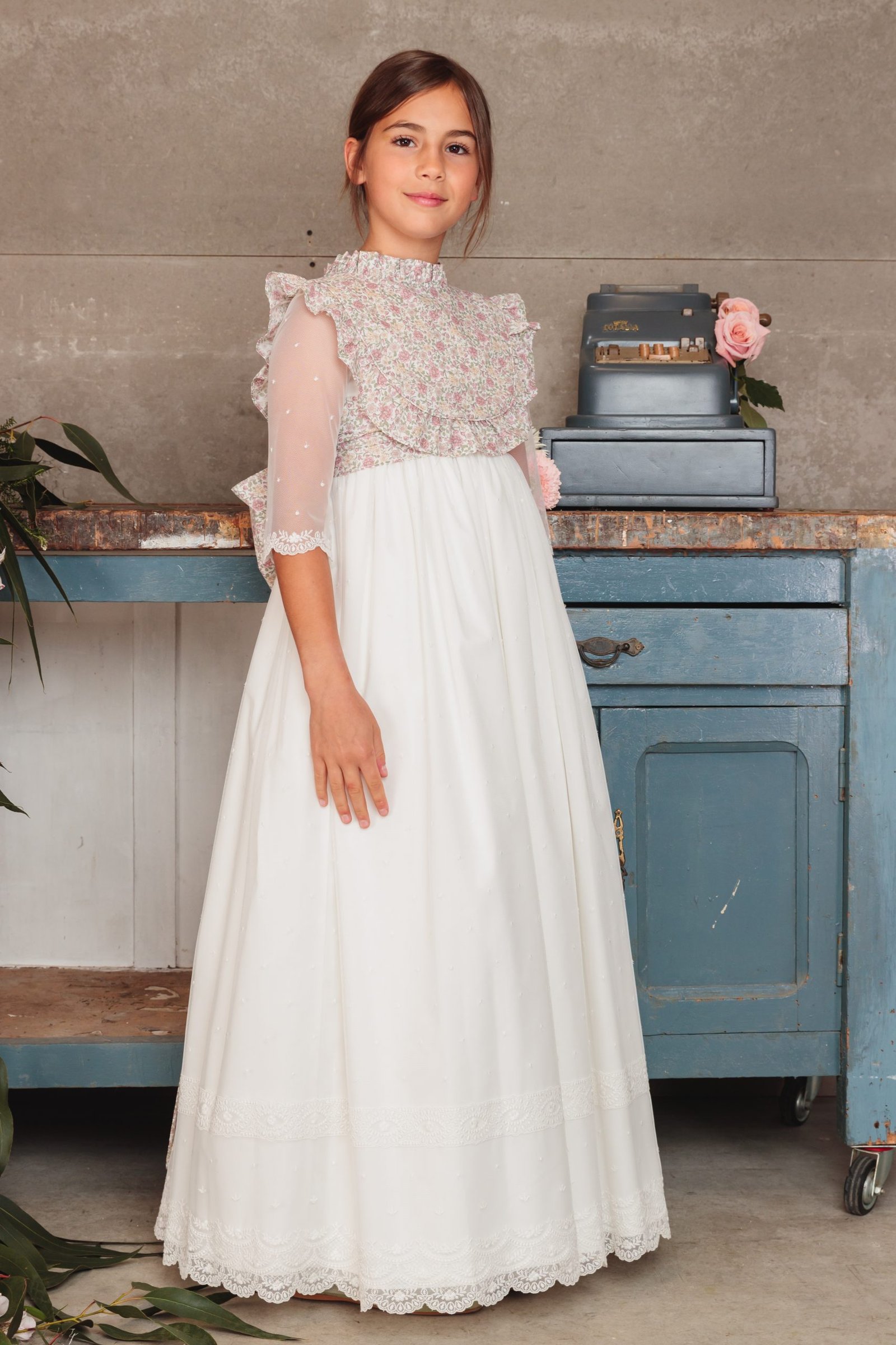 Vestido de comunión niña 2025 blanco con capa floral rosa, mangas tres cuartos y falda larga, exclusivo en MartaMolina.com