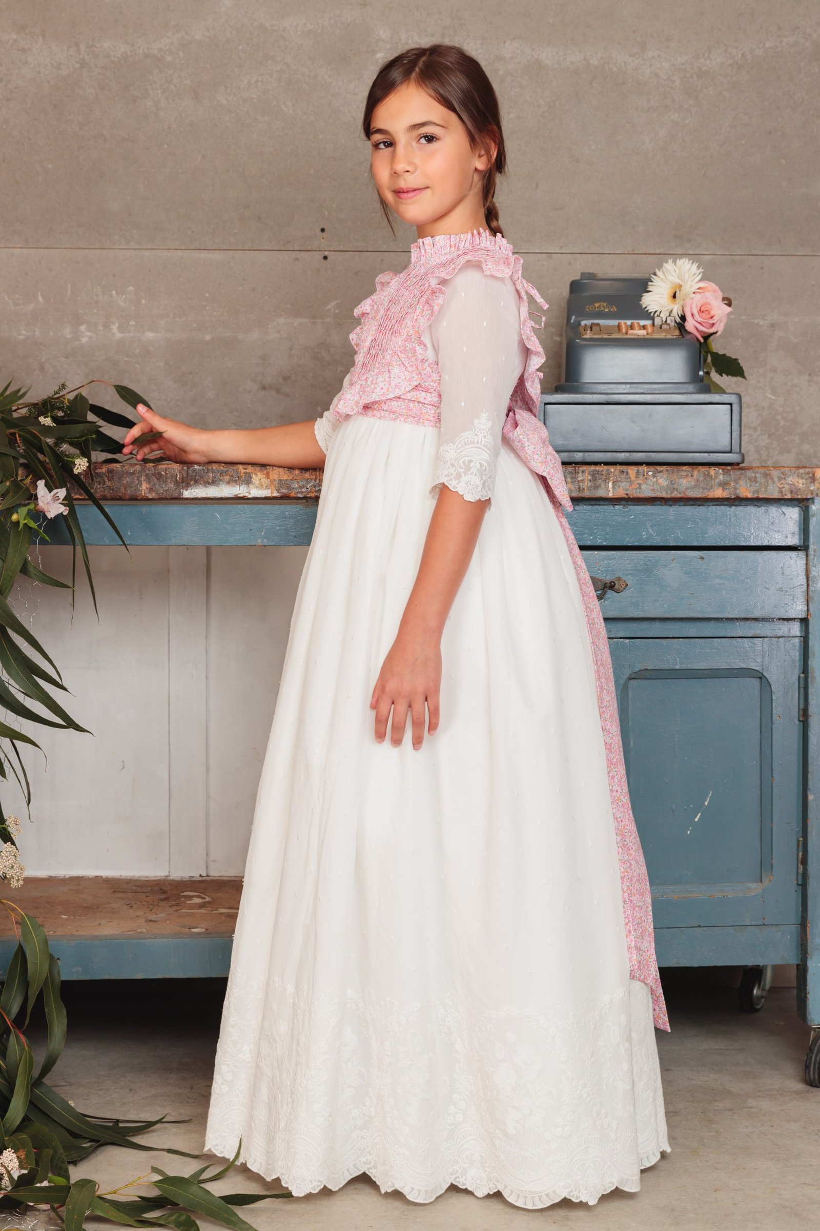 Vestido de comunión niña 2025 blanco con capa larga rosa, mangas tres cuartos y falda amplia, exclusivo en MartaMolina.com