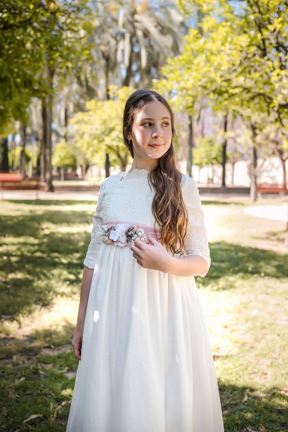 Vestido comunión Julieta Infantil 2025, manga tres cuartos, encaje, cinturón floral rosa, estilo romántico en jardín